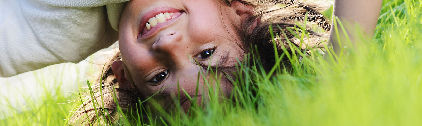 Kind macht Kopfstand im Gras